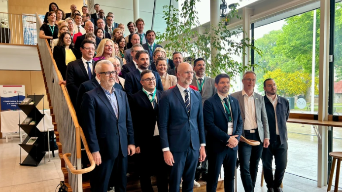 Personer står på rad i en bred trappa. Gruppbild.